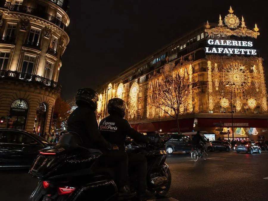Moto-taxi Express Gold Paris devant les Galeries Lafayette illuminées la nuit